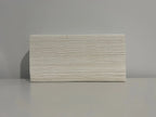 Stack of white disposable paper hand towels on a grey surface